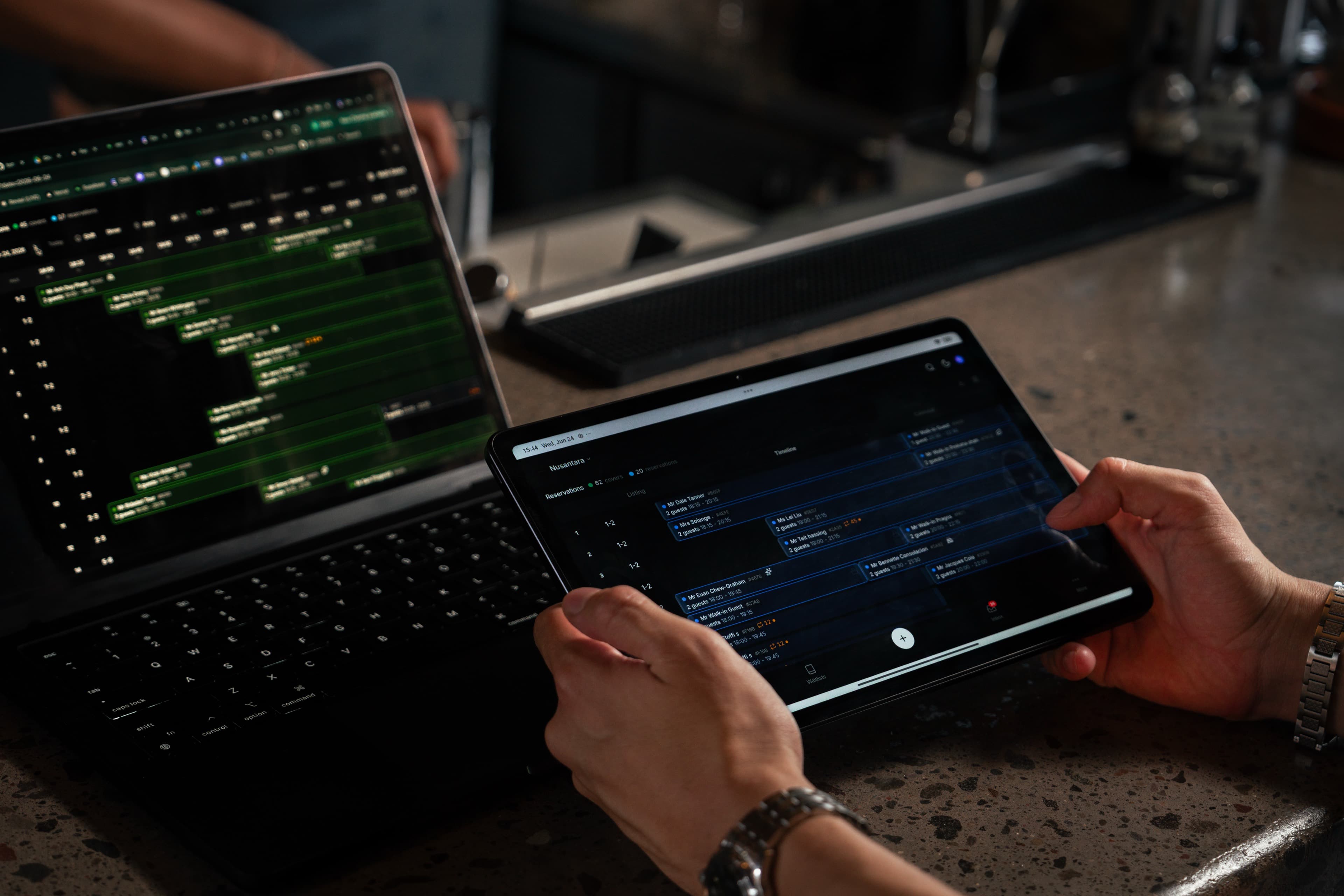 A host managing the reservation timeline on a tablet and laptop